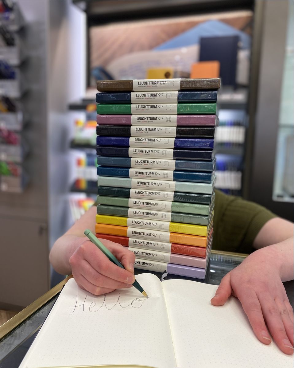 PtB staff hiding behind a stack of Leuchtturm notebooks in different colours. Whimsy!