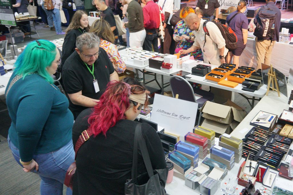 Two visitors look at the Melbourne Pen Depot table