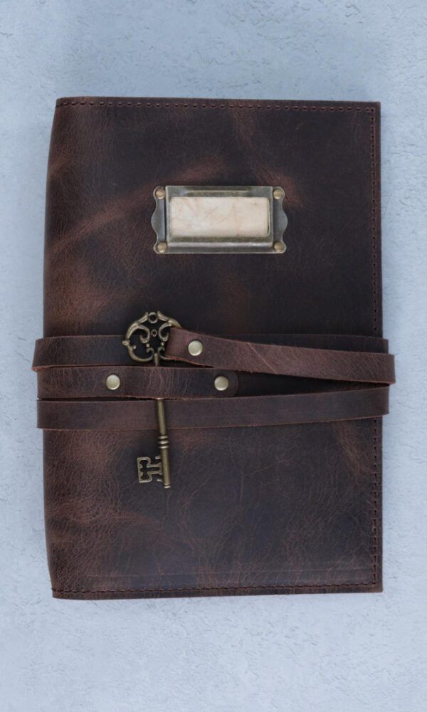 a dark brown leather notebook cover embossed with an illustration of a dragon