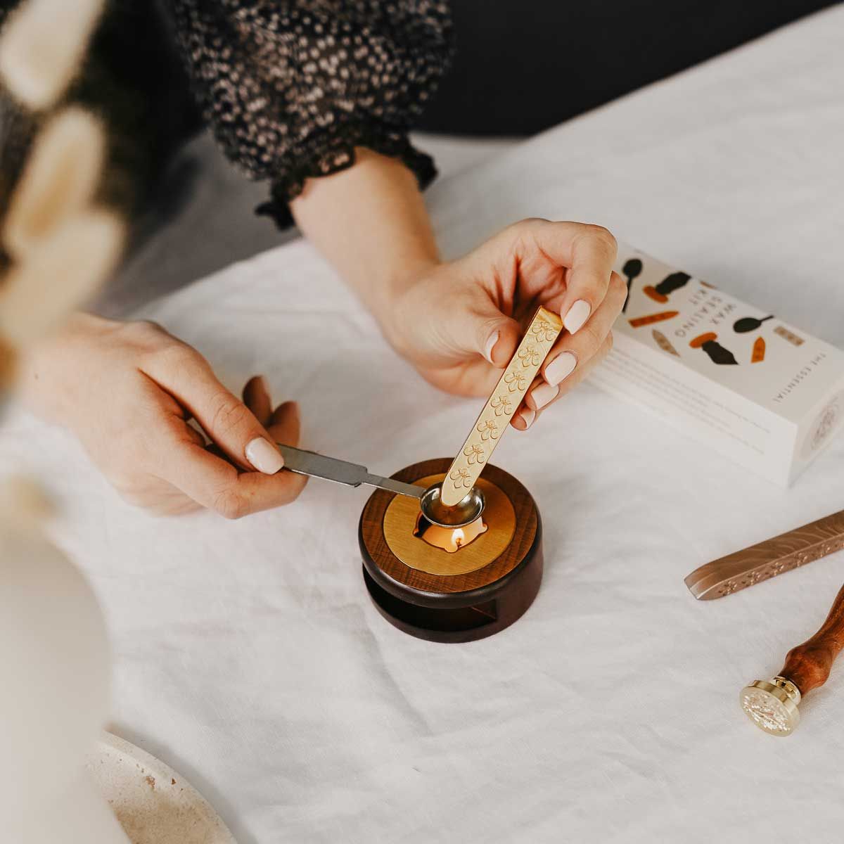 Melting sealing wax on a spoon holding wax stove
