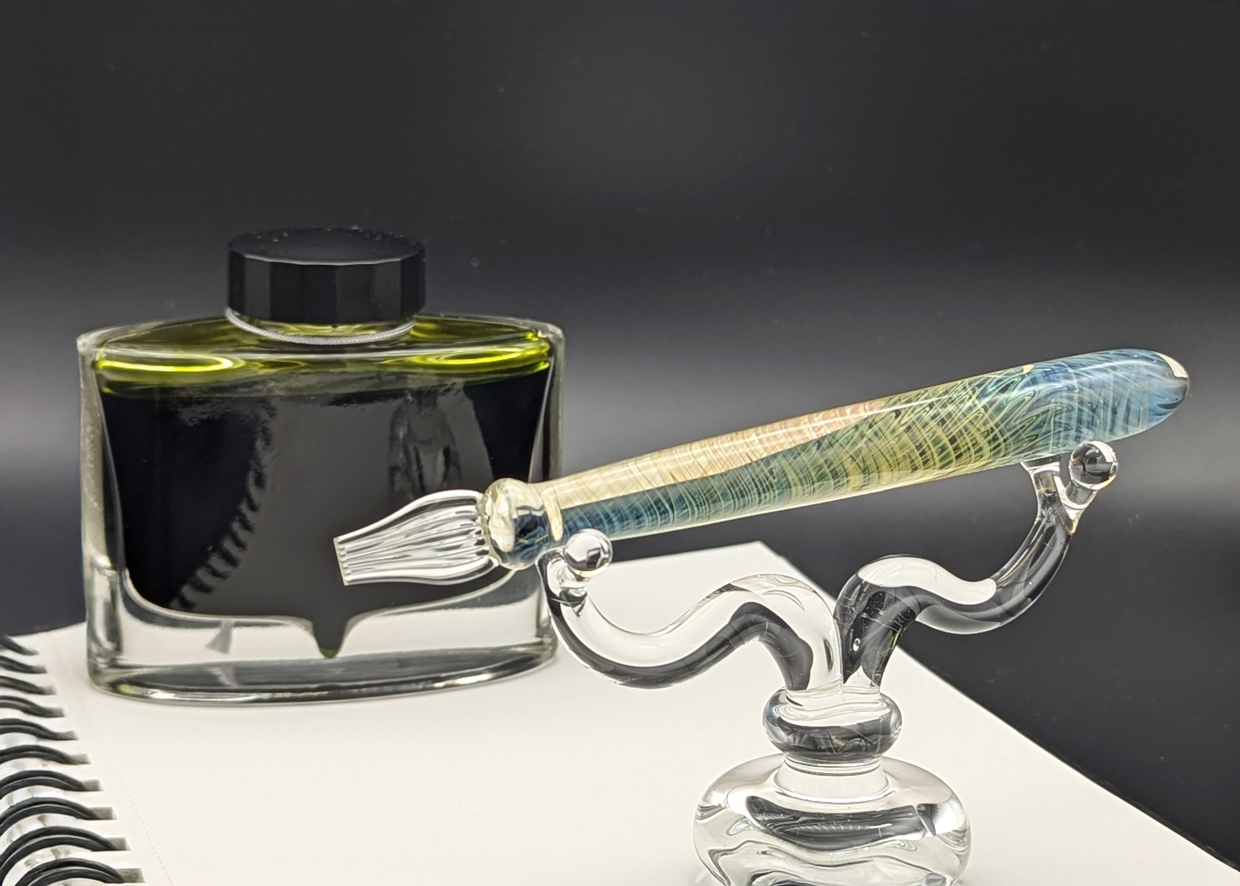 Borosilicate glass dip pen with ribbon nib, clear glass with intricate spiral pattern in blue and yellow