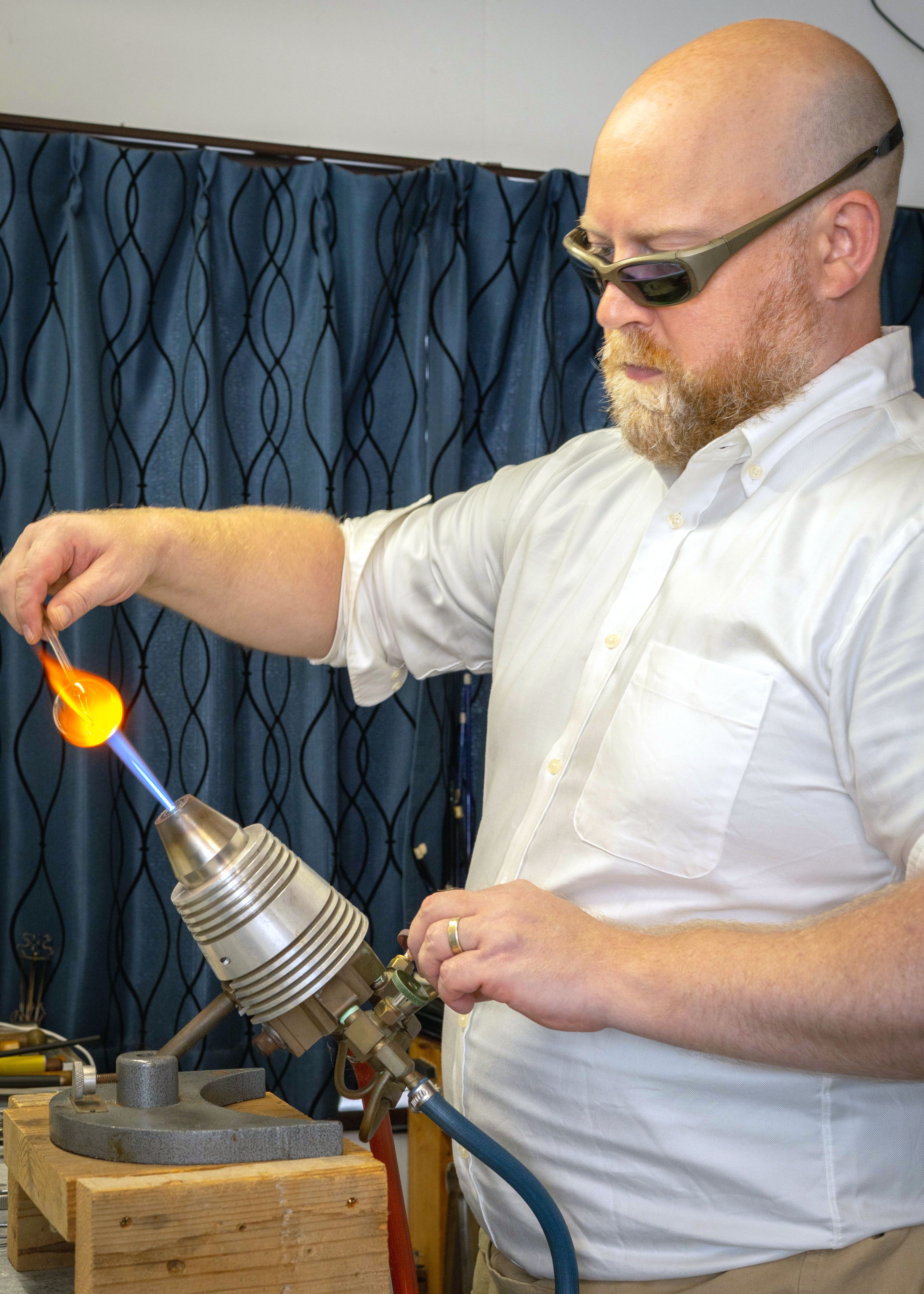 Lucas Mahoney in his workshop, fuming precious metals into borosilicate glass