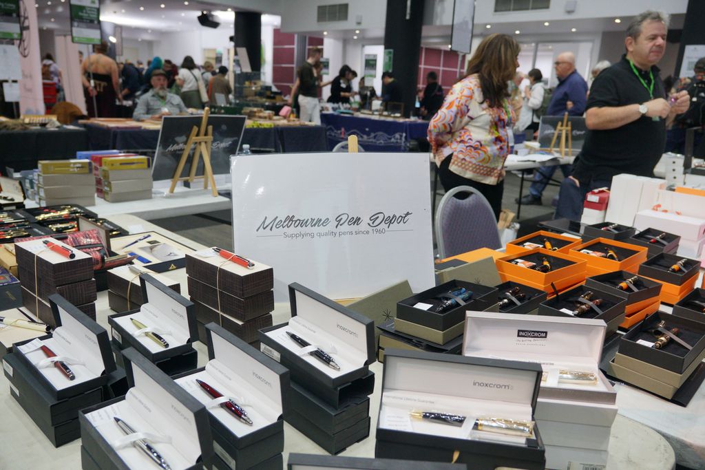 A sign on a table surrounded by pens: