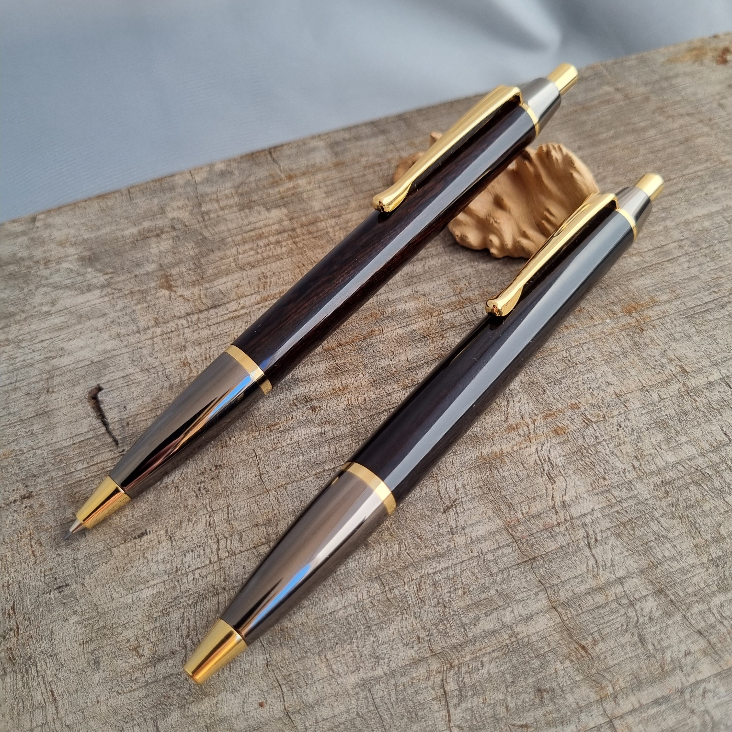 two black wood and metal rollerball pens