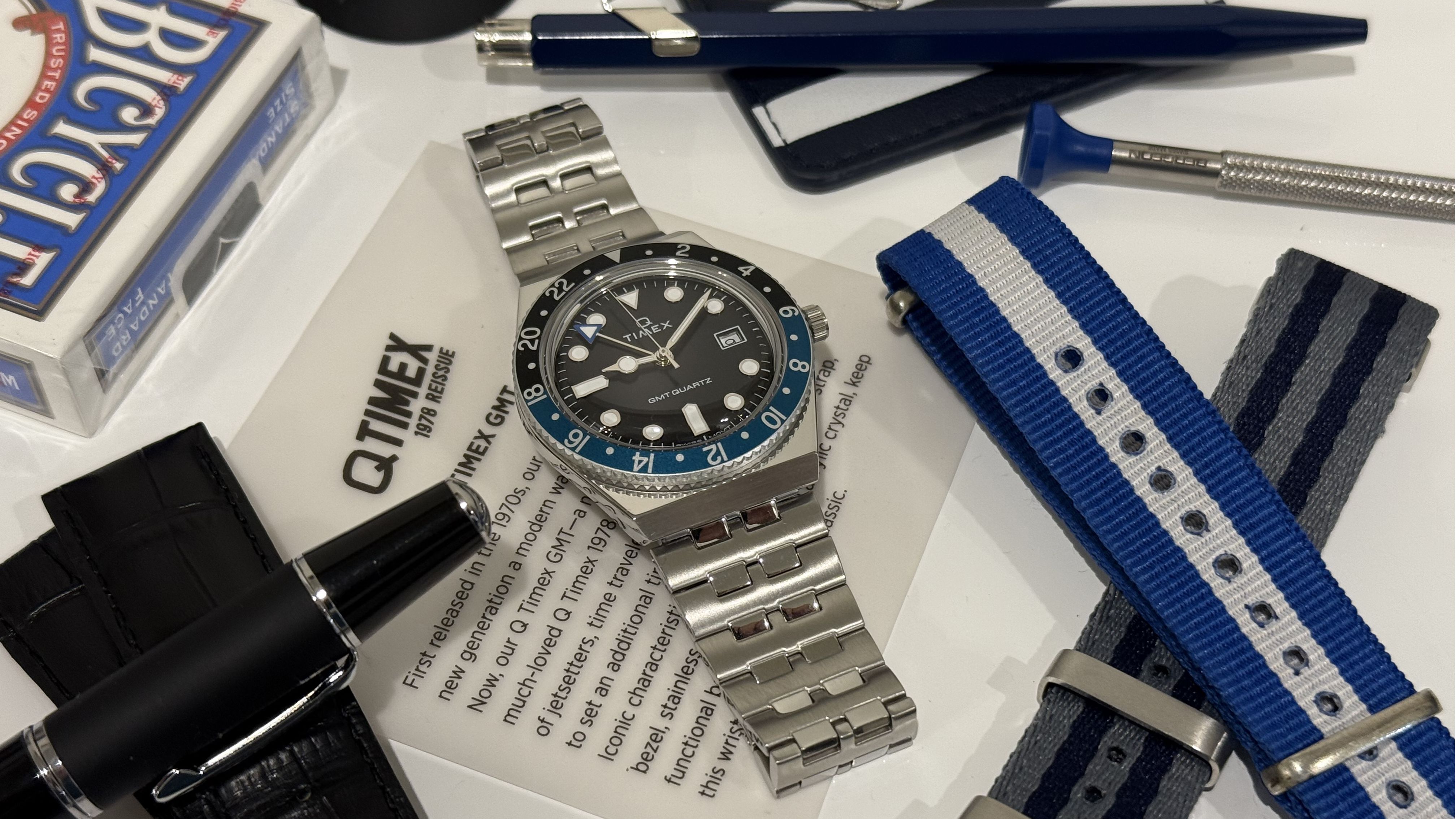 watch, strap, pens, playing cards, golf tee