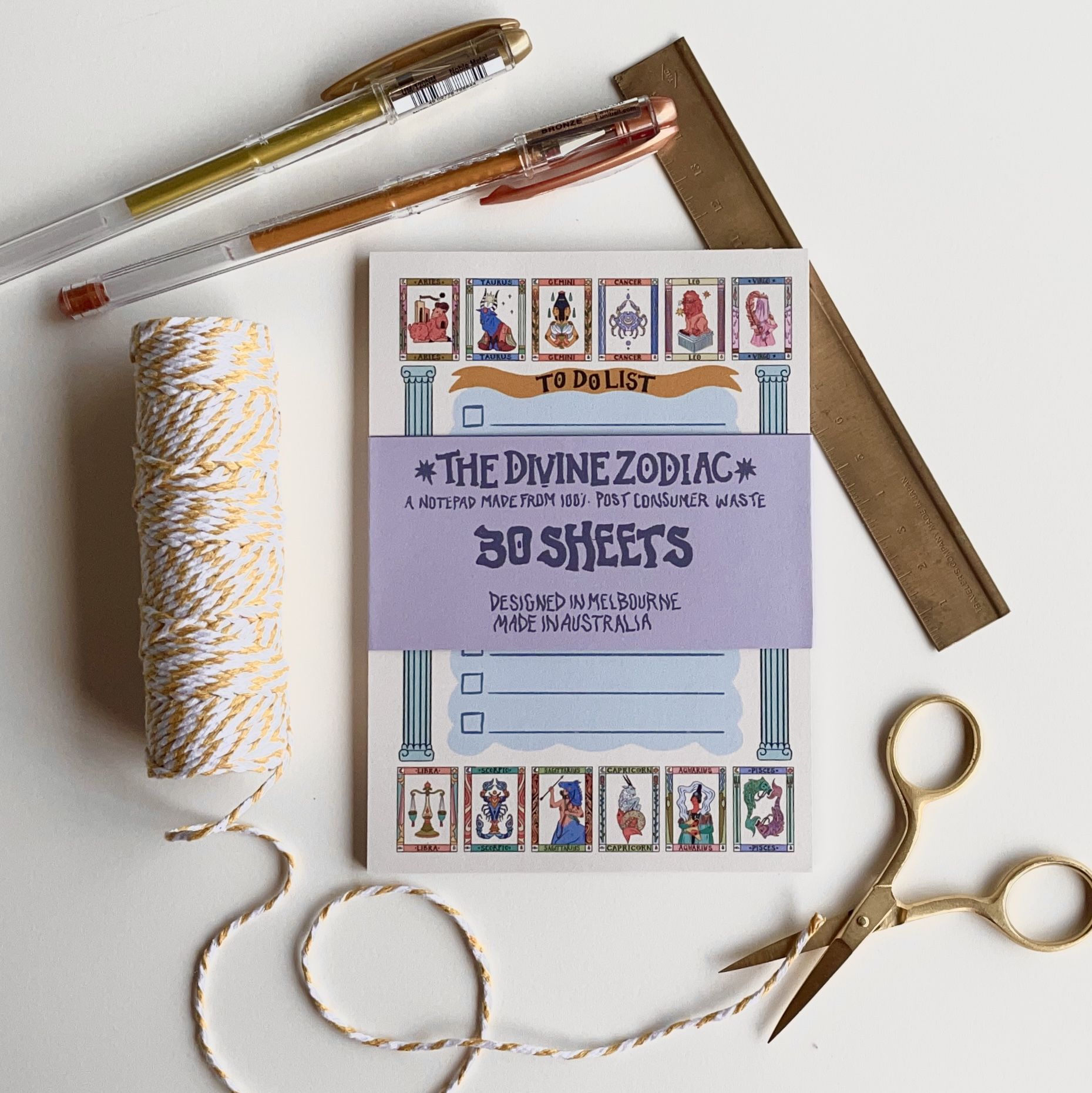 Zodiac themed note pad with stationery items surrounding it