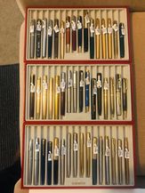 a large tray of pens with price tags