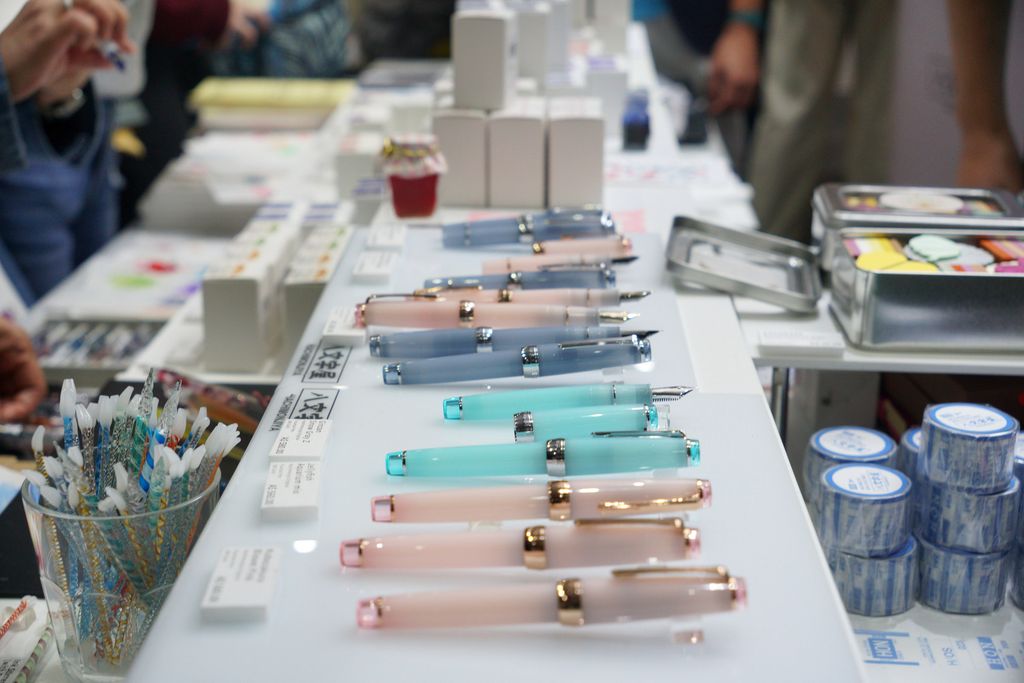 A row of pastel-coloured pens on an exhibitor's table