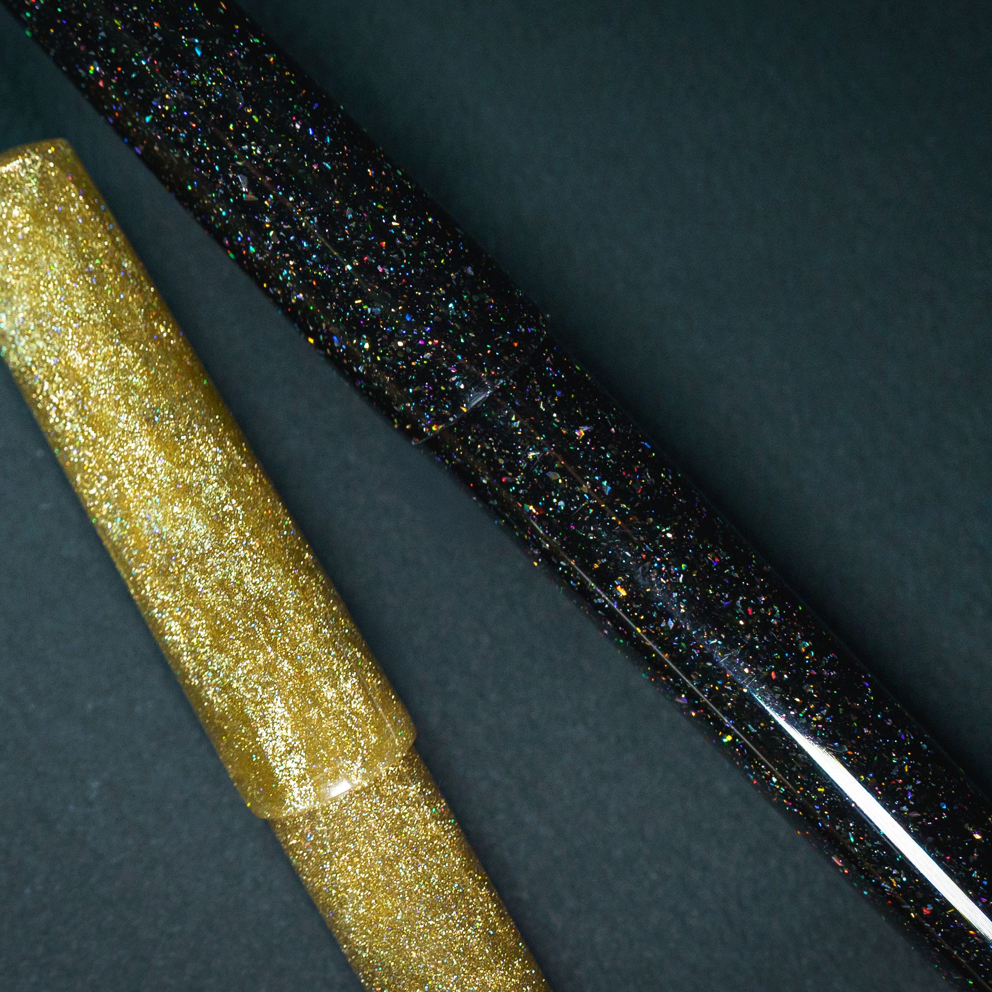 close up of two DiamondCast pens, one gold, one black