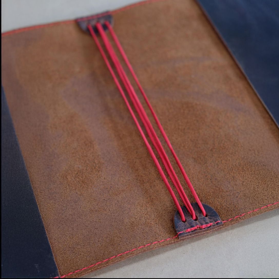 Inside leather notebook cover with red elastic bands