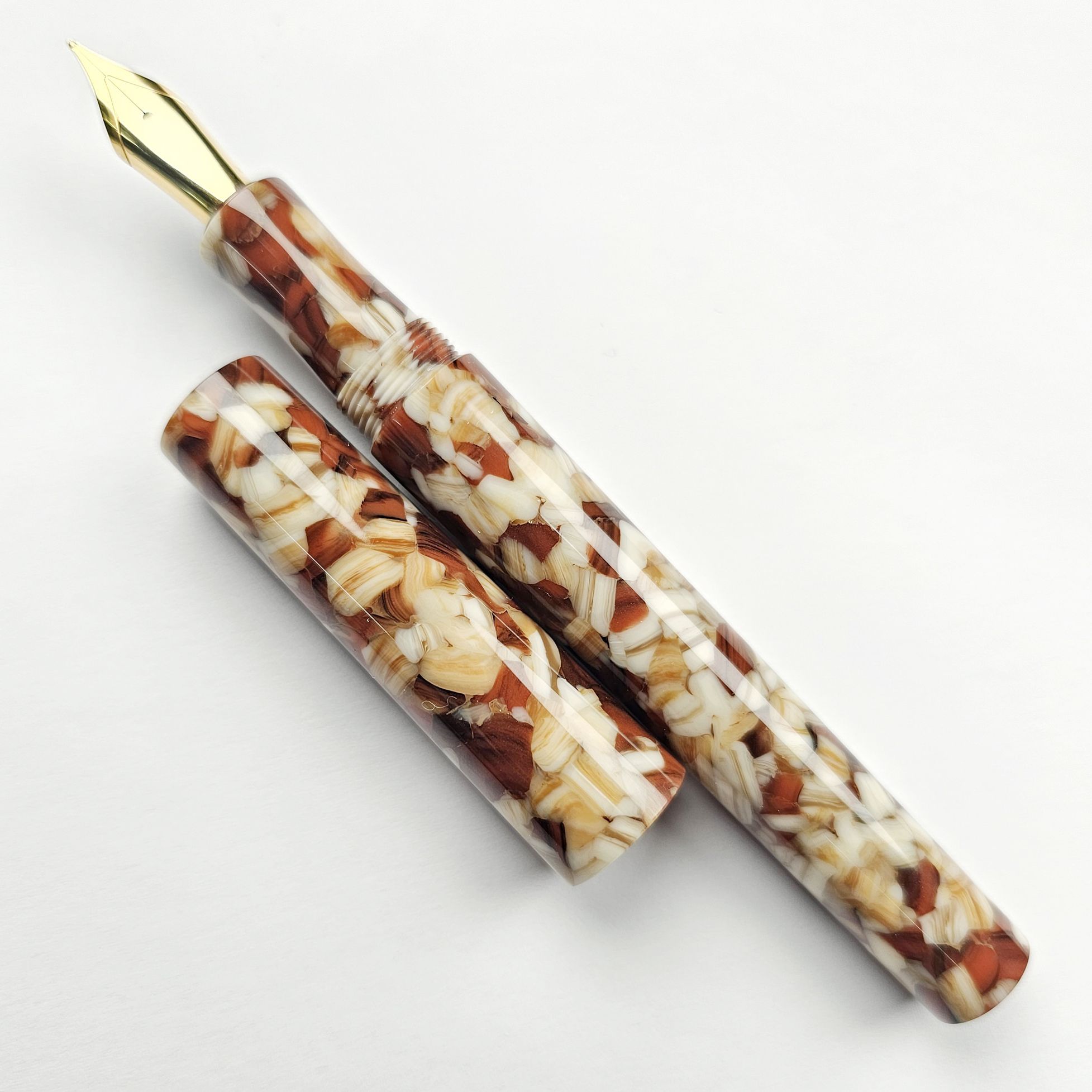 a hand-turned pen in glossy resin with what looks like barley, wheat, rice grains embedded in it