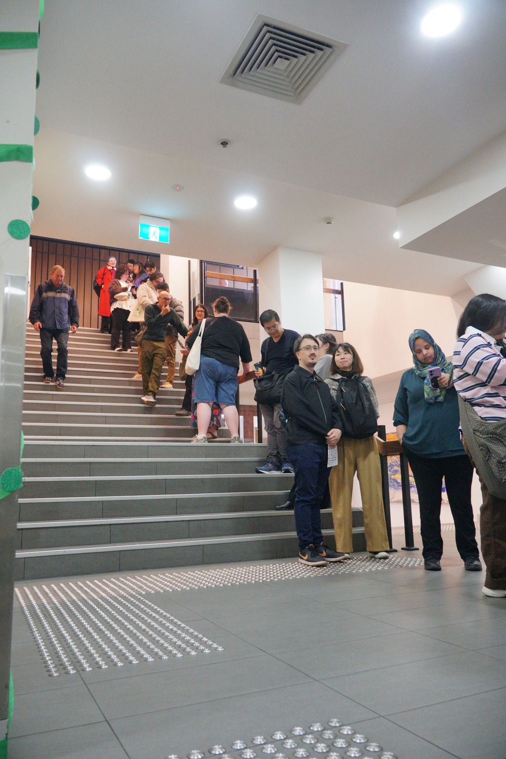 Visitors queue down a flight of stairs