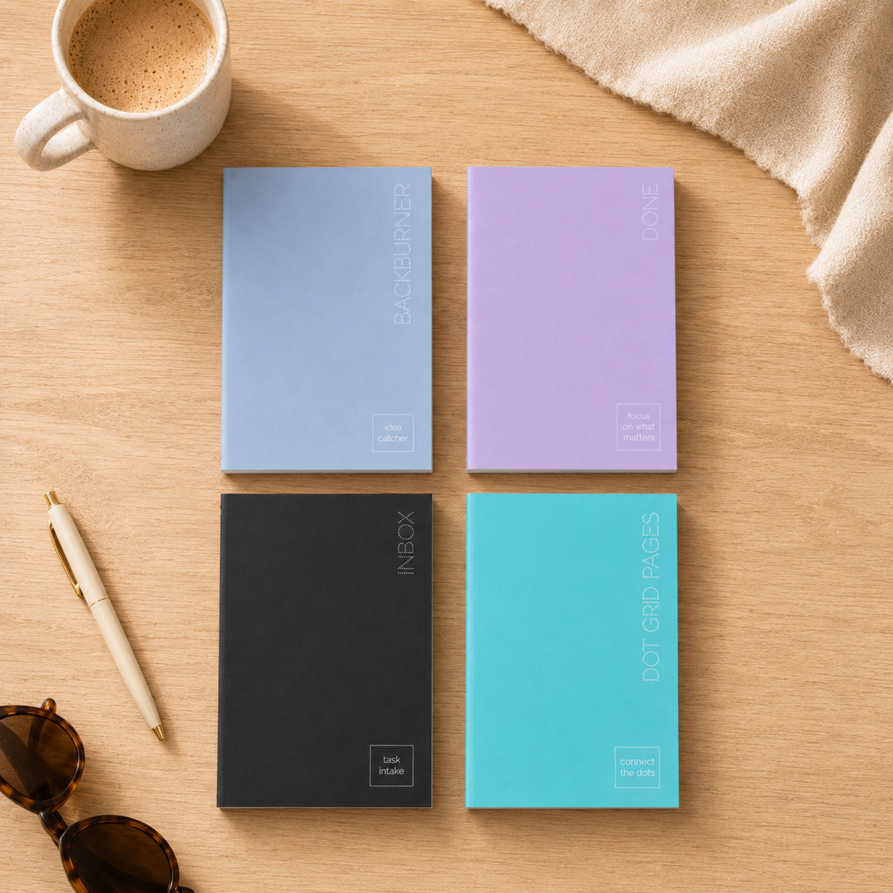 four journal insert notebooks in black, aqua, blue, and mauve