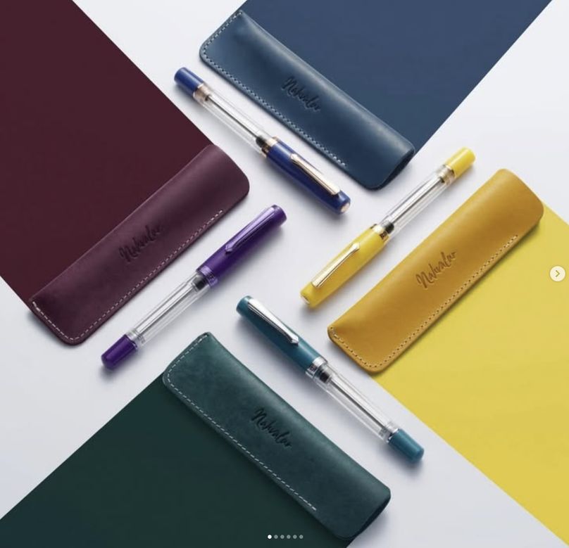 four TWSBI fountain pens and matching coloured pen cases