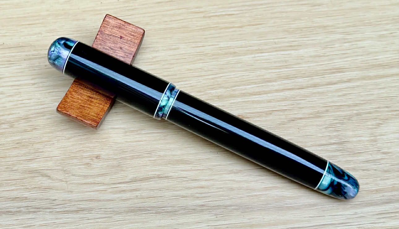 fountain pen with teal, black and white finials
