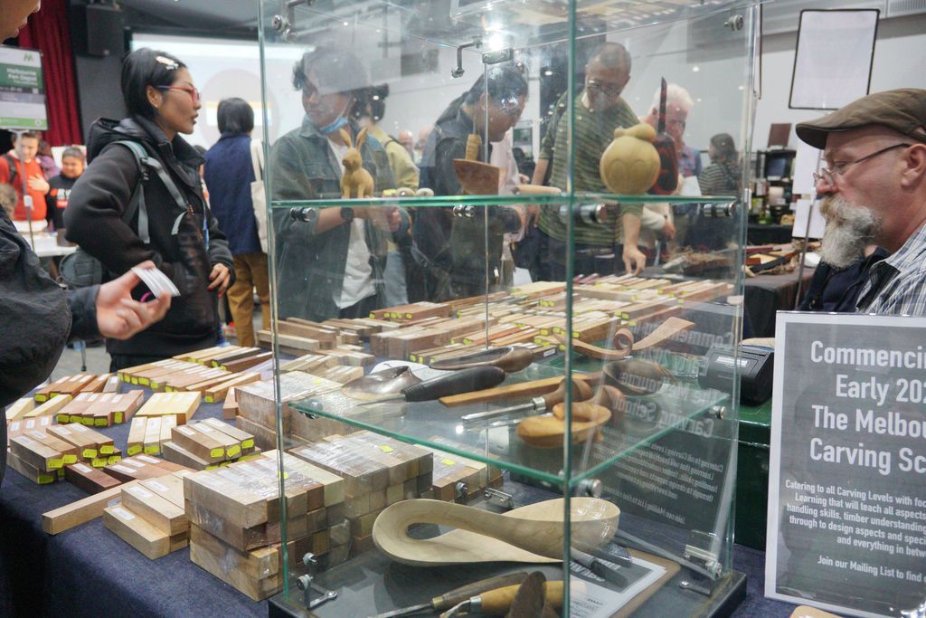 Wood carving tools in a glass case at an exhibitor table