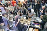 An exhibitor table seen from above, with a crowd of visitors