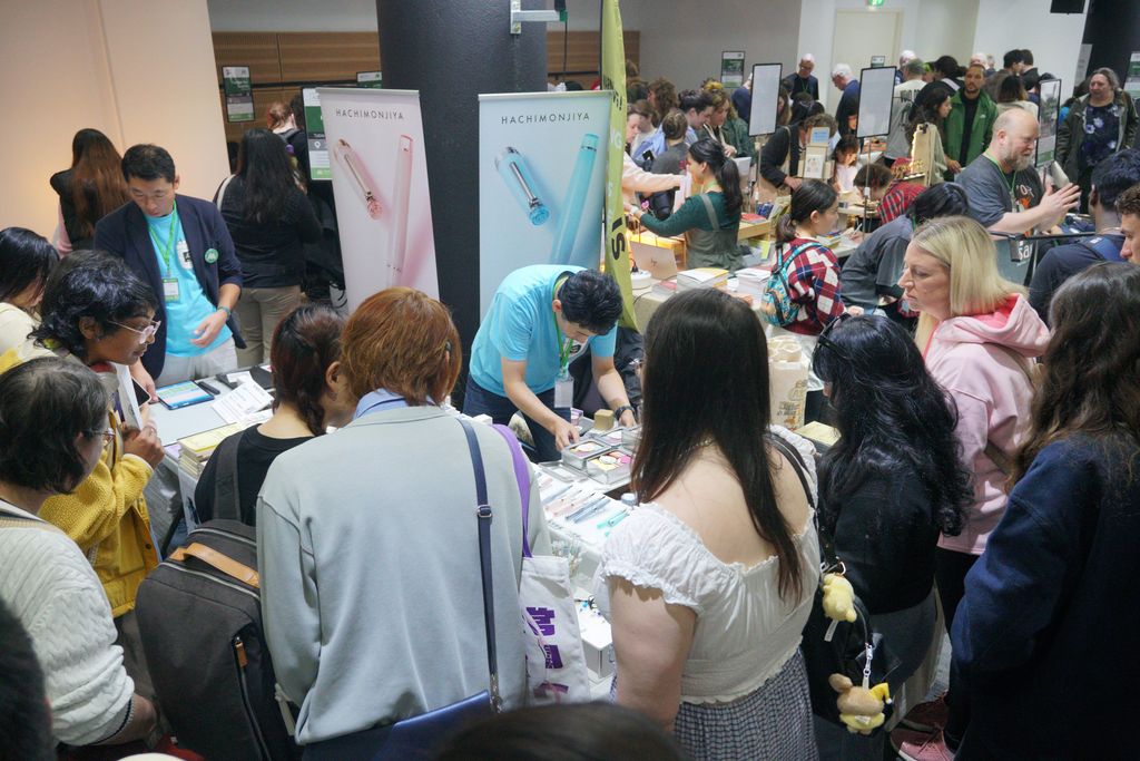 A crowd of visitors around the Hachimonjiya table