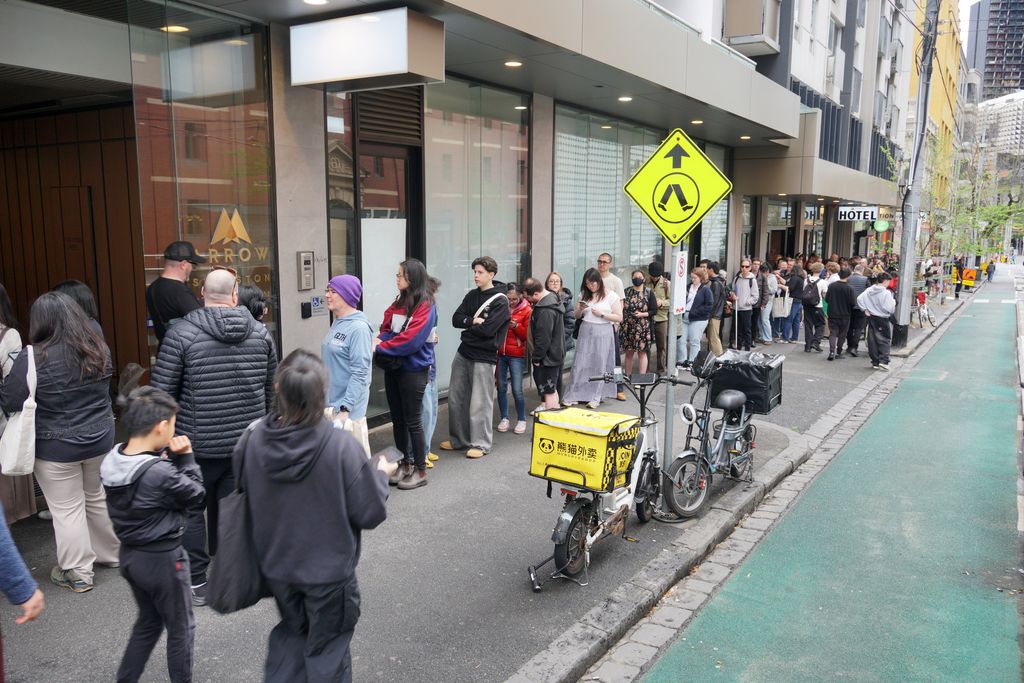 A long queue of people down the sidewalk